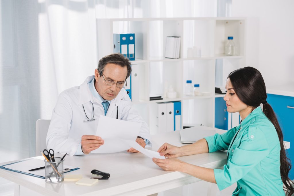 nurse and doctor sitting and reading documents